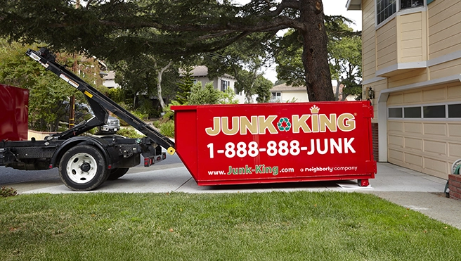 Junk King professionals dropping off a dumpster to a customer.