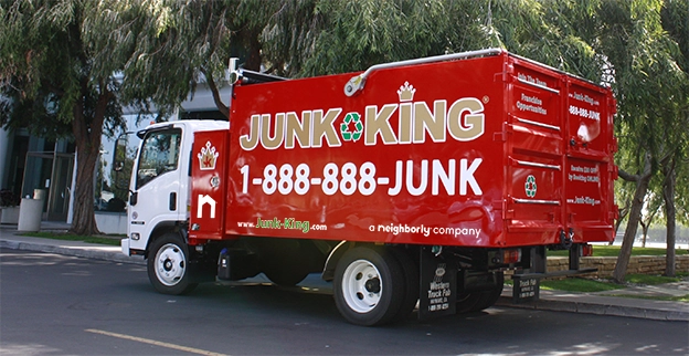 A branded Junk King dump truck parked on the street.