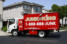 Junk King truck parked in front of a residential building.
