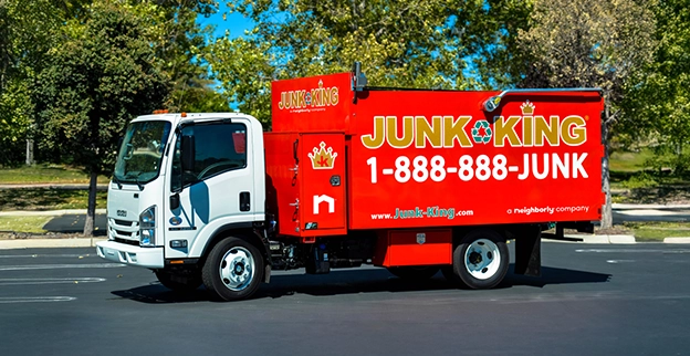 A branded Junk King dump truck parked on the street.