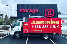 Junk King dump truck parked in front of a storage facility.