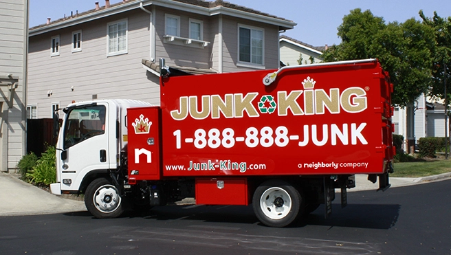 Red Junk King truck parked in front of a home.
