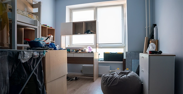 An apartment room full of old desks and furniture.