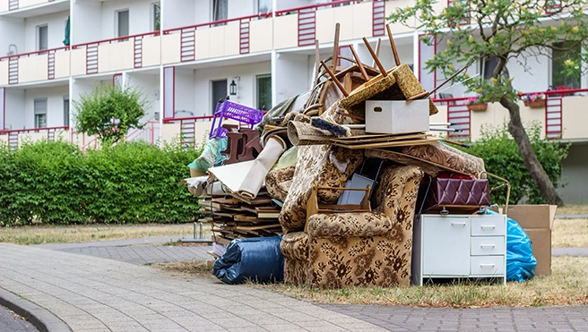 Pile of junk sitting outside of an apartment building.
