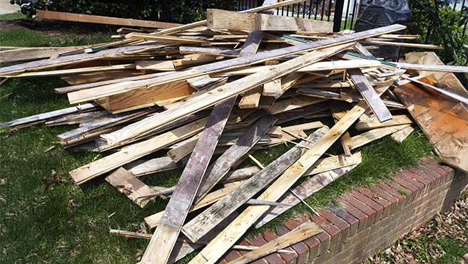 A backyard with a large pile of boards.