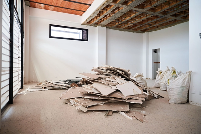 A room with a pile of construction debri piled on the floor.