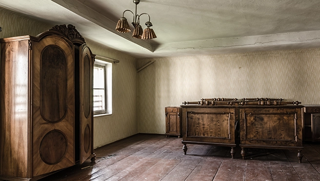 Photo of a room with an armoire and other furniture.