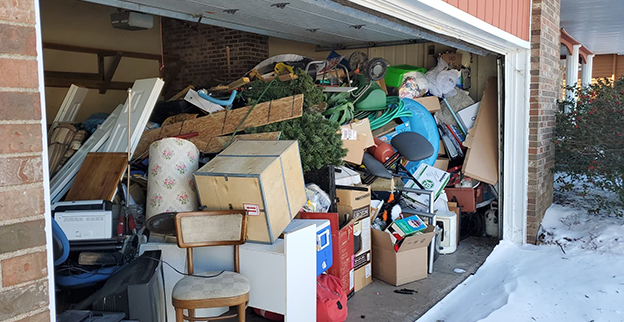 A garage completely full of old furniture and miscellaneous items.