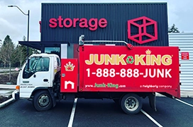 red Junk King dump truck in front of a storage facility.