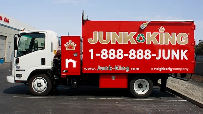 Junk King truck with phone number and Neighborly branding displayed on the side.