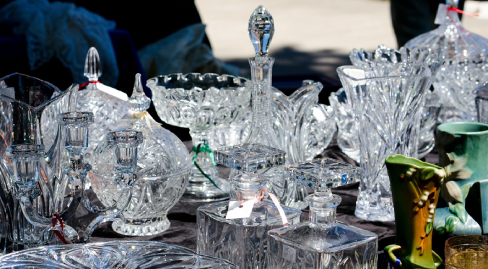 A table topped with lots of glass vases and dishes.