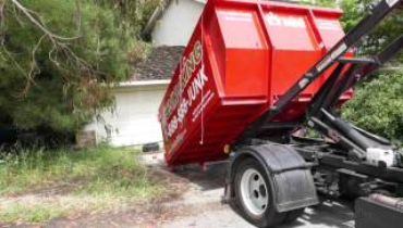 Junk King Truck Dropping Off A Dumpster