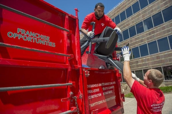 junk king workmen loading office furniture on a truck