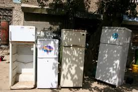 A group of old refrigerators sitting next to each other.