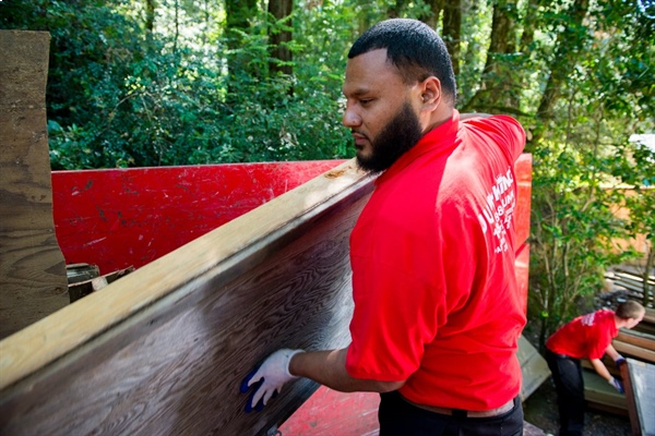 A Junk King technician working on a piece of wood.